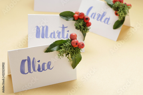 How to make christmas place name cards with handwritten letters and fresh plants © agneskantaruk