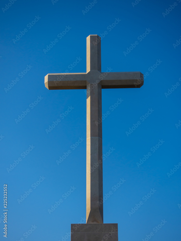 Christian cross outdoor against clear blue sky.