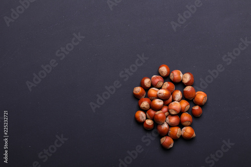 Handful of hazelnut on a black background - healthy snack.