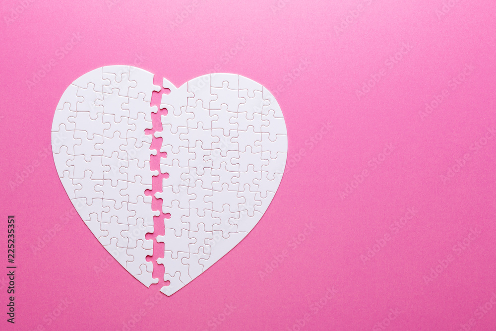 Fototapeta premium White puzzle heart on pink background. Missing piece. Top view