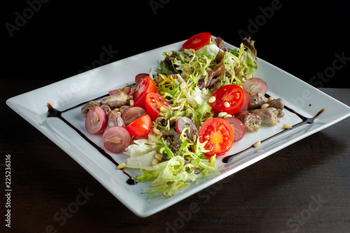 Chicken hearts, vegetable salad. Sprinkled with pine nuts. photo