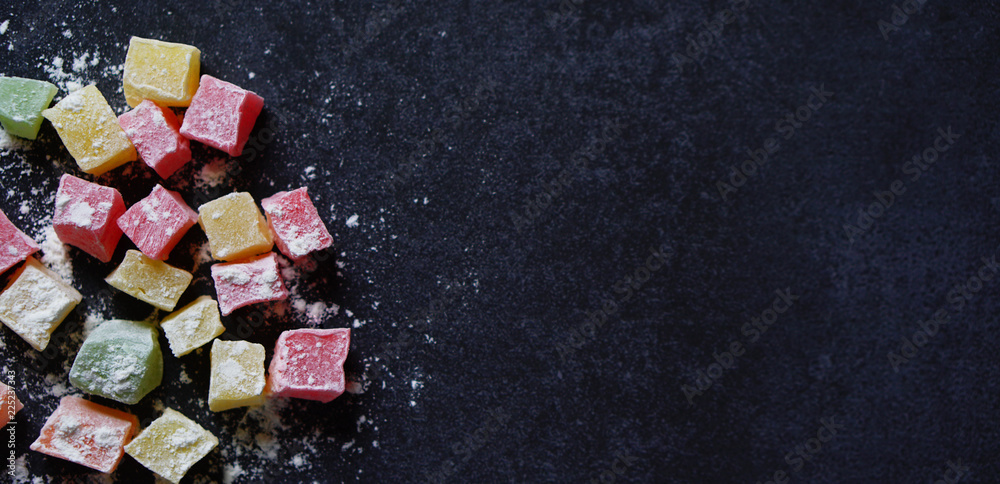 Fototapeta premium Colorful Traditional Turkish Delight on black background with a copy space on right