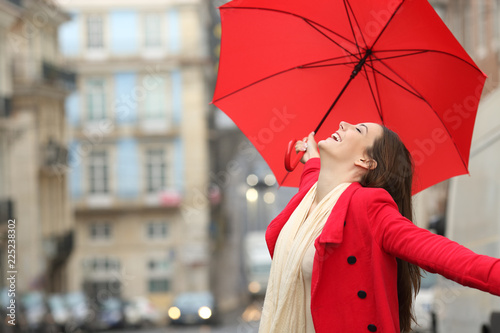 Spontaneous woman celebrating under the rain in winter