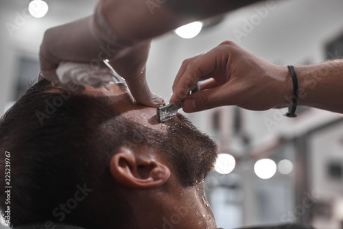 Hair Care. Men's hairstyles in hairdressing salons. Barber makes a haircut and beard to his client. © callisto