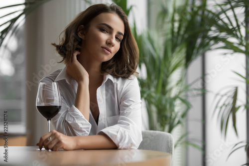 Young woman with a red wine glass sitting in the restaurant