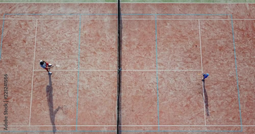 Little boy playing tennis. The boy is practicing tennis. Sports training of children. Aerial view. Little boy playing tennis. The boy is practicing tennis. Sports training of children. Aerial view.