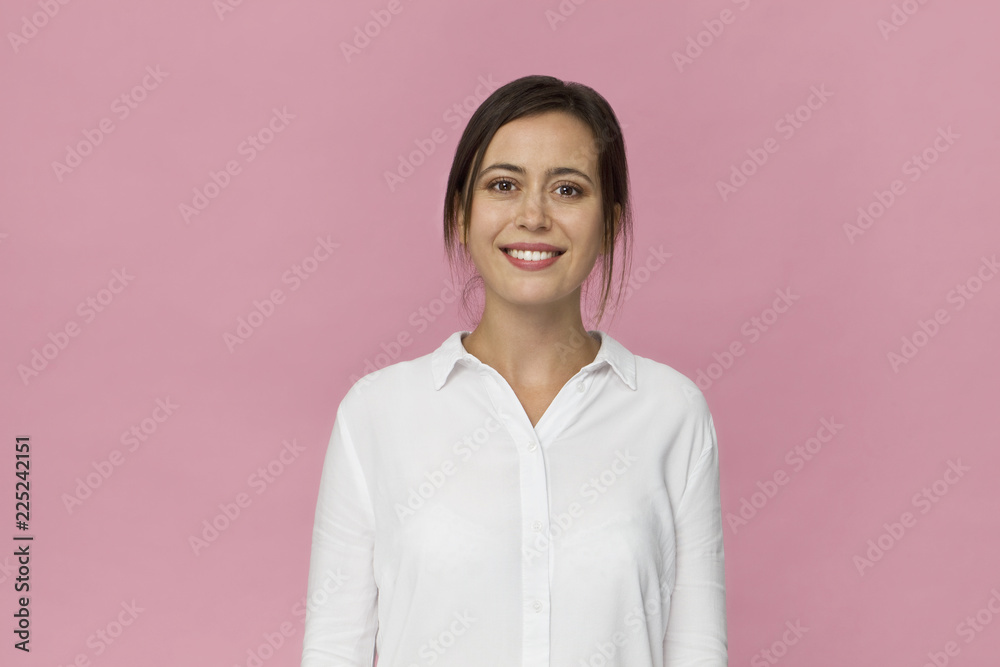 Smiling positive female close up with attractive look posing against pink background Smiling positive female close up with attractive look posing against pink background