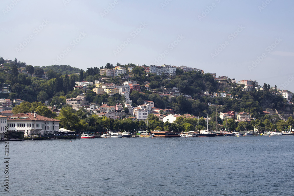 Fototapeta premium View of motorboats and yachts, Bosphorus, buildings in Kurucesme neighborhood on European side of Istanbul. It is a sunny summer day.