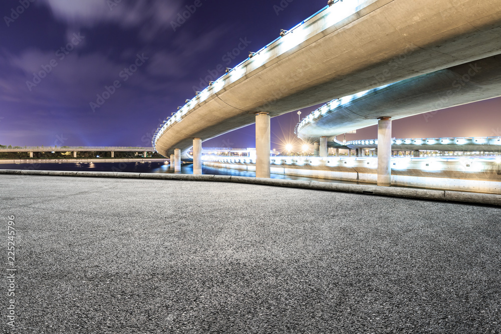 Asphalt road and modern bridge building scenery at night Asphalt road and modern bridge building scenery at night