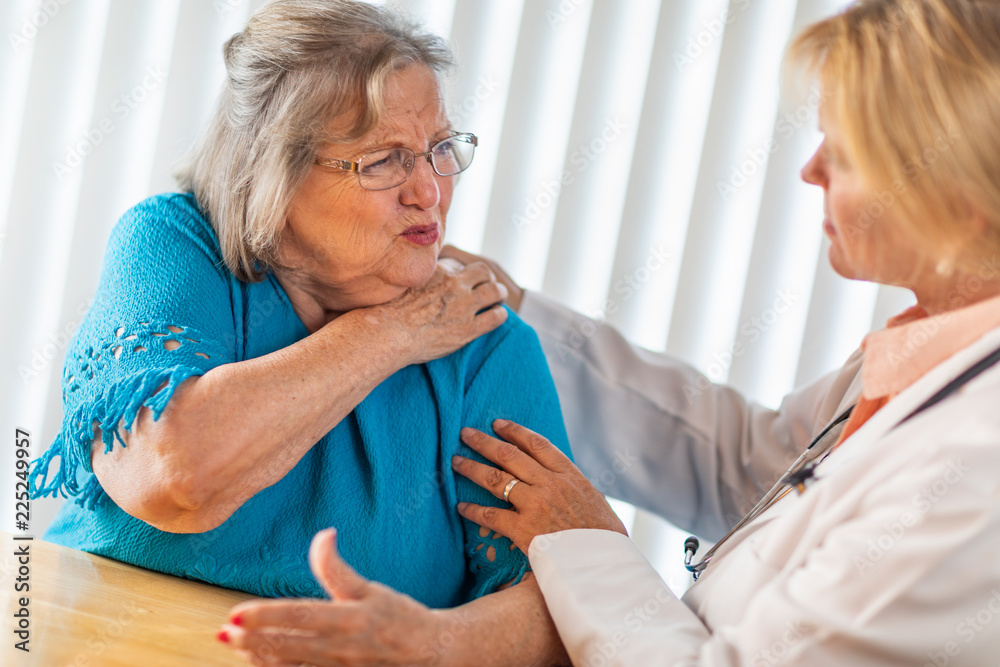Obraz premium Senior Adult Woman Talking with Female Doctor About Sore Shoulder