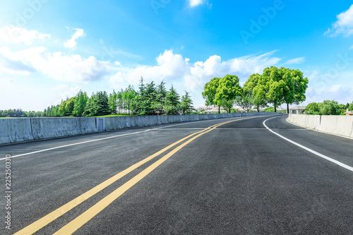 Asphalt highway and green forest natural scenery under the blue sky