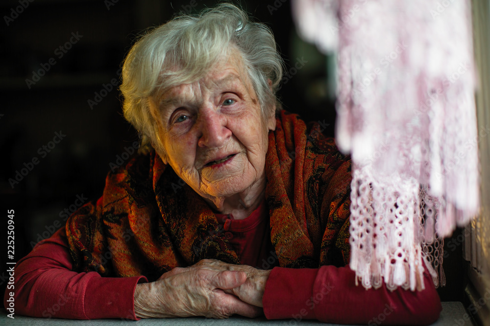 Portrait of elderly woman sitting at the table. Portrait of elderly woman sitting at the table.