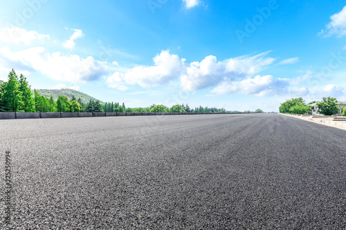 Asphalt highway and green forest natural scenery under the blue sky © ABCDstock