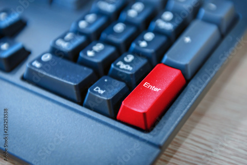 Close-up of computer keyboard with red button. selected focus on enter button.