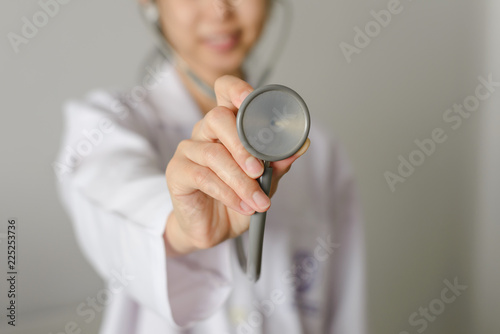 Close up of female doctor standing and holding stethoscope for check patient with copy space