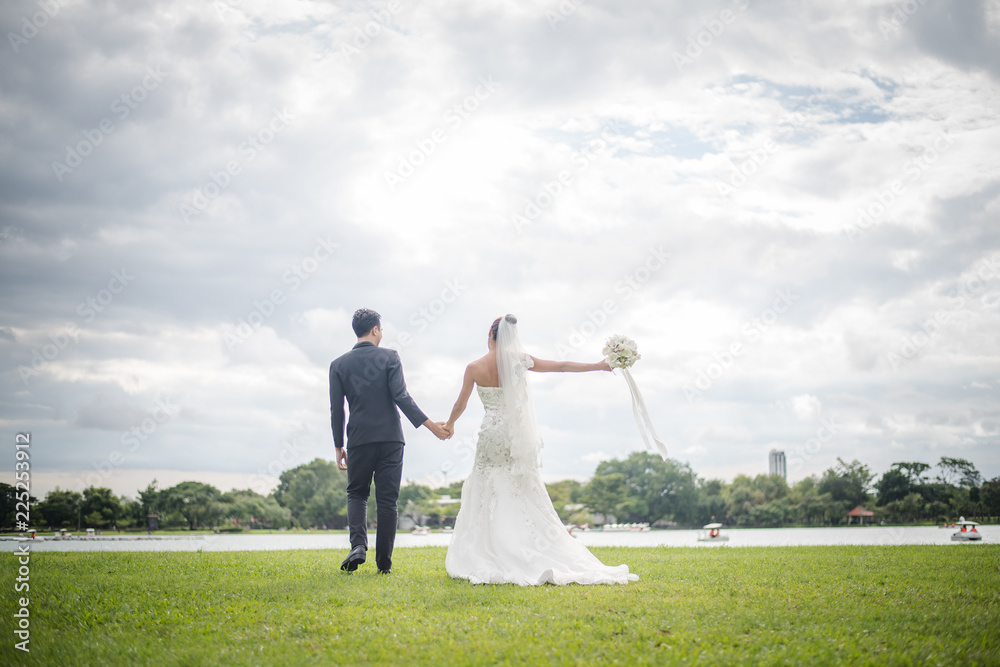 Happy smiling couple in wedding. Pretty Bride and handsome groom gorgeous posting in the nature. Happy smiling couple in wedding. Pretty Bride and handsome groom gorgeous posting in the nature.