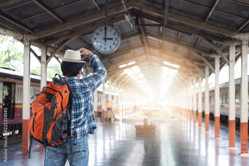 Asian traveler man with belongings waiting for travel by train at Chiang Mai train station, Thailand