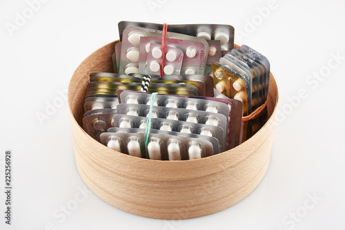 Blister pack with tablets in round wooden box