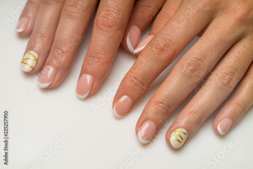French manicure and nail gel Polish. The decoration of the nail white and gold decor. Top view Close-up photography