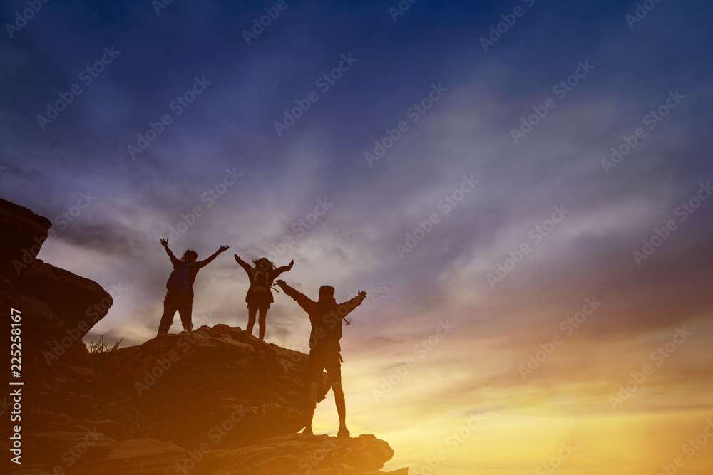 Teamwork friendship hiking help each other trust assistance silhouette in mountains, sunrise.