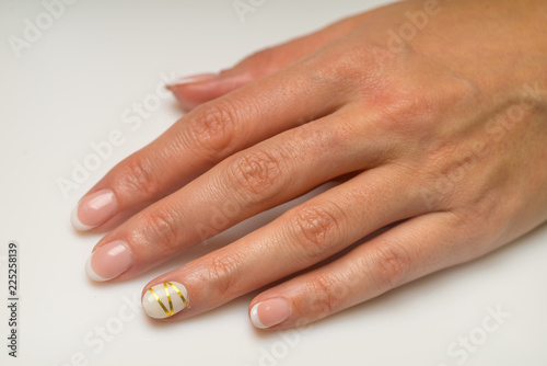 French manicure and nail gel Polish. Young  perfect  groomed woman s hands with pink and white nail varnish bottles.