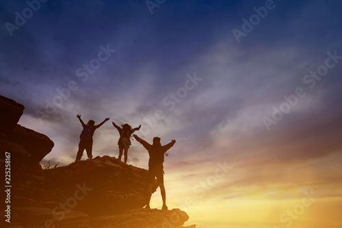 Teamwork friendship hiking help each other trust assistance silhouette in mountains  sunrise.