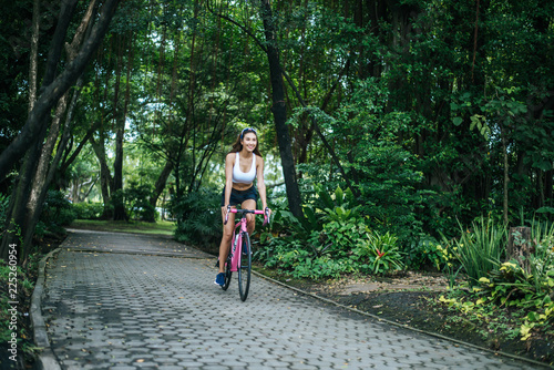 Wallpaper Mural Woman riding a road bike in the park. Portrait of young beautiful woman on pink bike. Torontodigital.ca