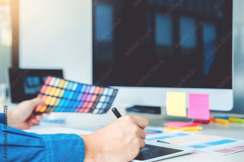 Graphic designer drawing on graphics tablet at workplace Graphic designer drawing on graphics tablet at workplace