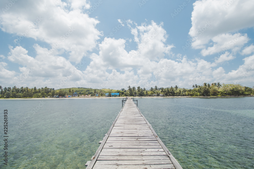 Wooden Dock, Clear Sea Water, Tropical Forest, Cloudy Sky and Tropical Beach