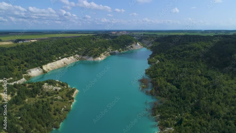 Slow flight over a large abandoned gypsum quarry. A quarry full of blue water.