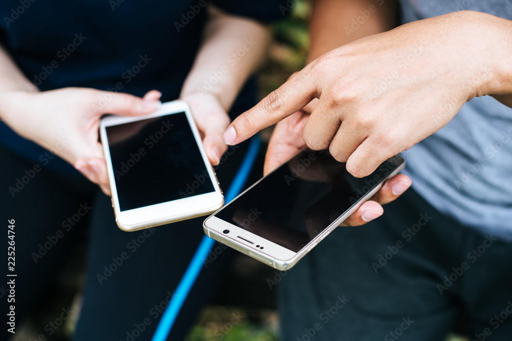 Close up of friends hands play with smartphone together.