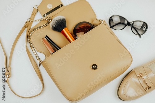 handbag with cosmetics. sunglasses. shoe. White background.
