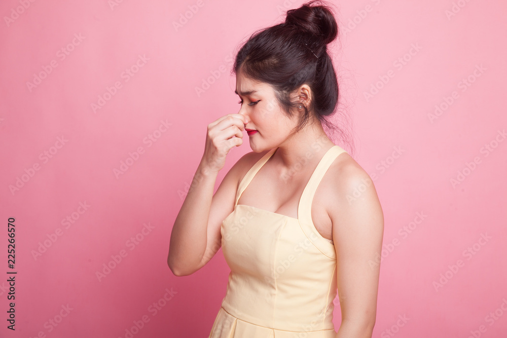 Young Asian woman holding her nose because of a bad smell. Young Asian woman holding her nose because of a bad smell.