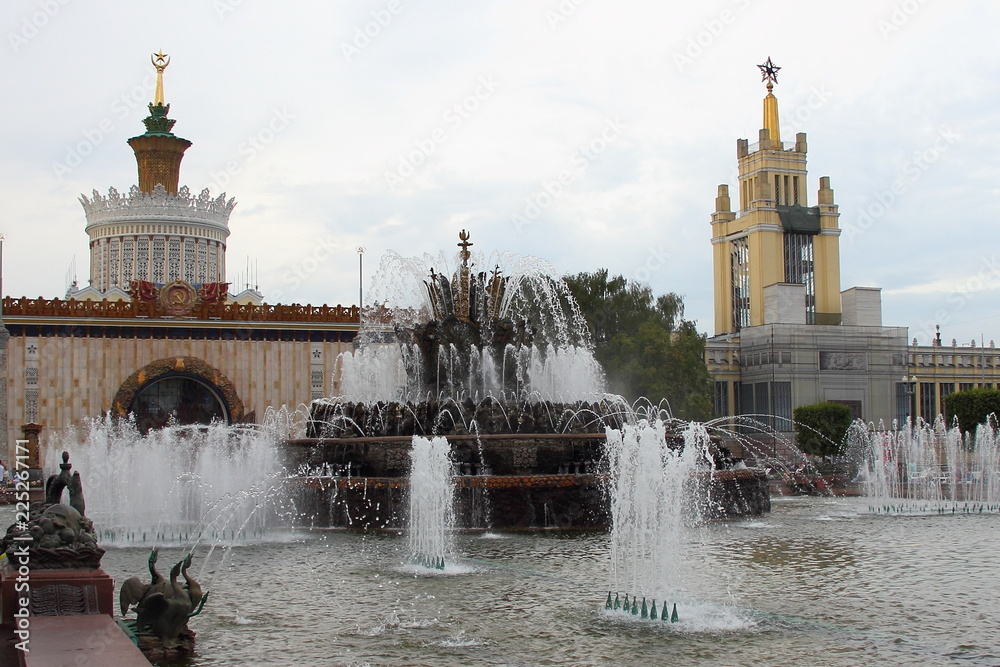 Moscow, Russia - Fountain sculpture Stone Flower on a background  Pavilion Zemledelie (farming, agriculture) # 58 at VDNKH (VVC), perspective view on water of gray sky on a summer day