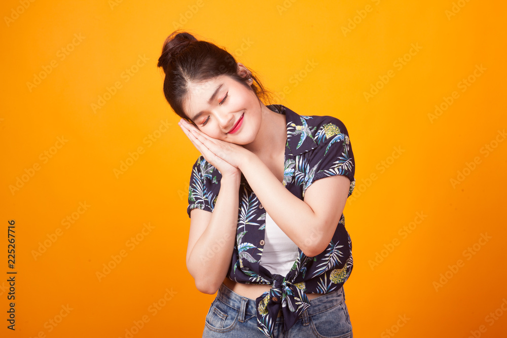 Beautiful young Asian woman with sleeping gesture in tropical shirt Beautiful young Asian woman with sleeping gesture in tropical shirt