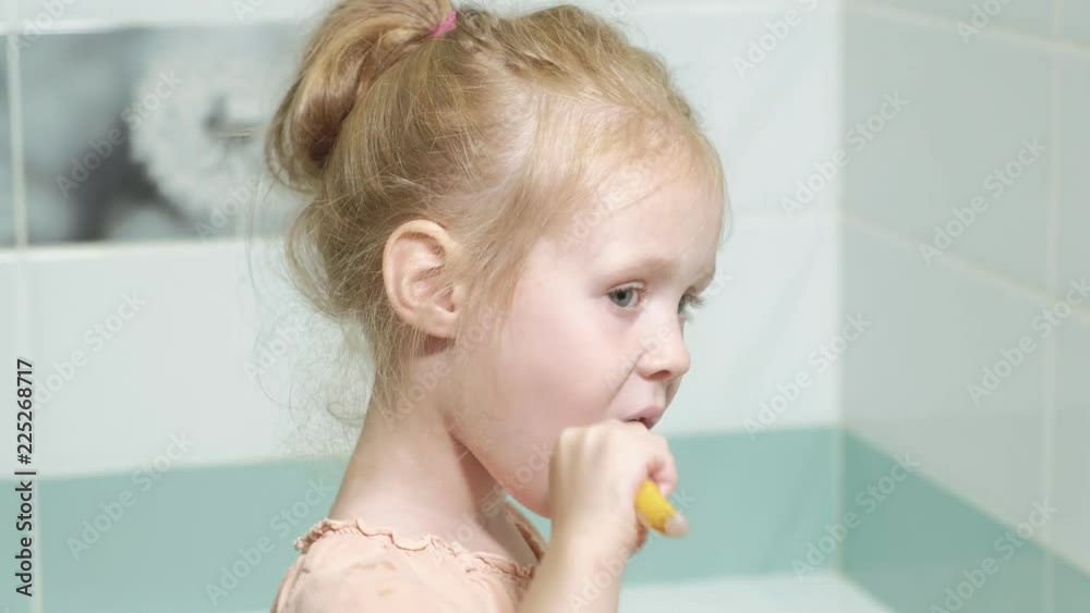 Little girl diligently brushing his teeth in the mirror. Little girl diligently brushing his teeth in the mirror.