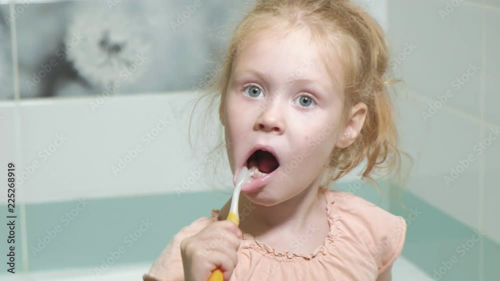 Little girl diligently brushing his teeth in the mirror. Little girl diligently brushing his teeth in the mirror.