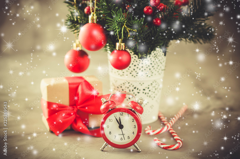Christmas composition: xmas fir branches, alarm clock, gift box and decorations.