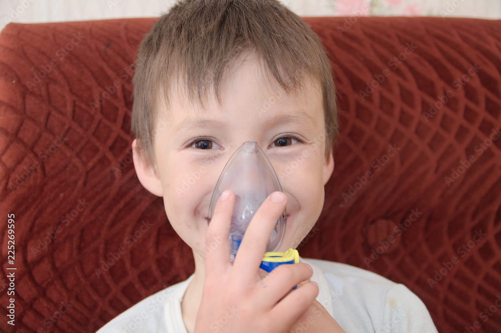 sick boy in nebulizer mask making inhalation, respiratory procedure by