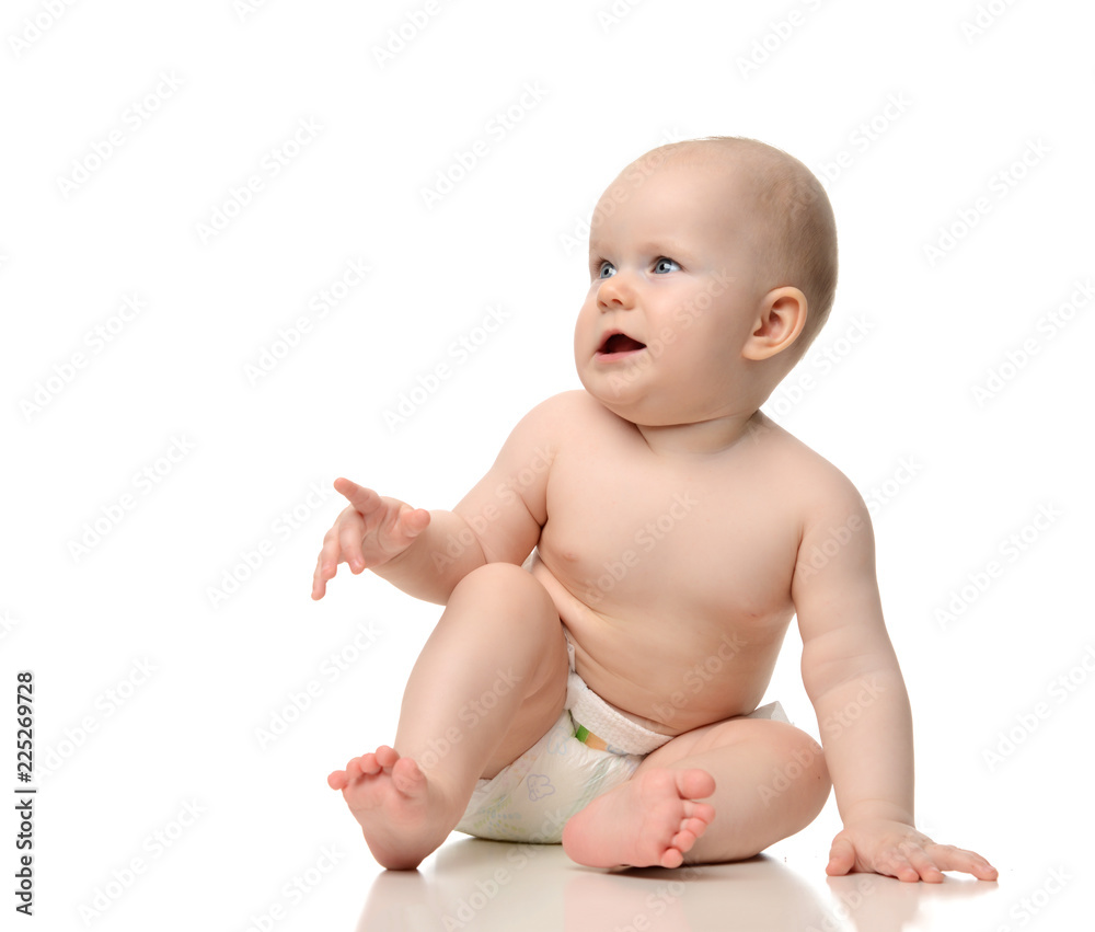 infant child baby girl toddler sitting on floor in diaper pointing finger up at the corner isolated on a white infant child baby girl toddler sitting on floor in diaper pointing finger up at the corner isolated on a white