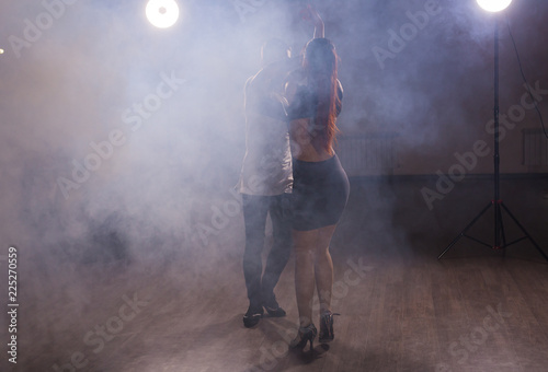 Fototapeta Naklejka Na Ścianę i Meble -  Young couple dancing social danse kizomba or bachata or semba or taraxia in dancing class background