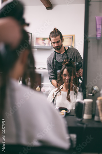 Young woman getting new hairstyle at professional hair styling saloon.