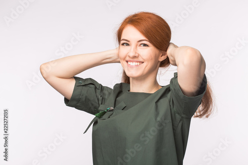 Fashion and people concept - beautiful young woman with red hair smiling over white background