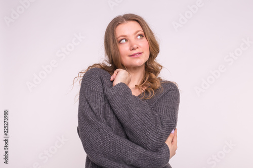 Young woman wearing grey wool sweater on white background © satura_