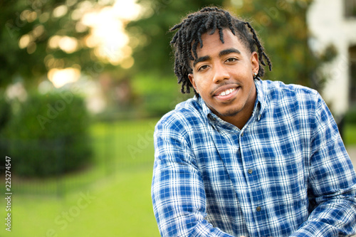 Young handsome African American man smiling outside.