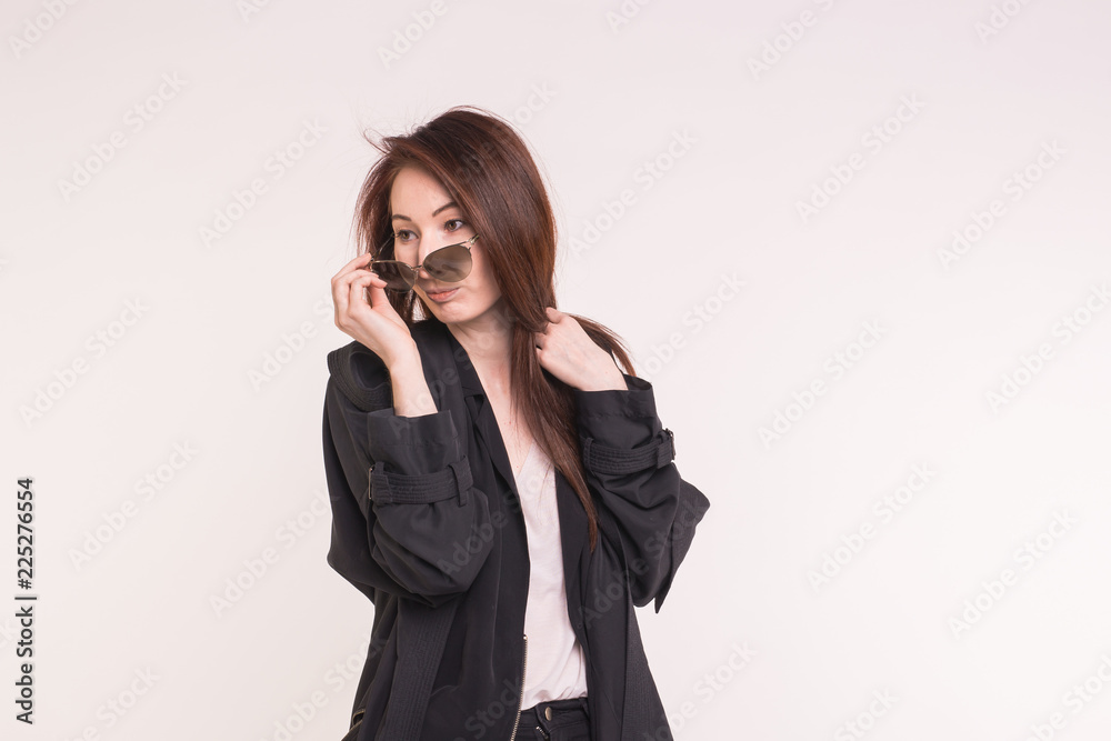 Fashion, modeling and people concept - young asian woman looking at you over the glasses over white background Fashion, modeling and people concept - young asian woman looking at you over the glasses over white background