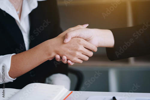 Businesswoman shaking hand for a complete business deal together successful.Finishing up a meeting. Teamwork  and Partnership concept .