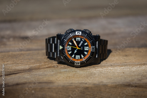 Black and orange diver watch on wooden table