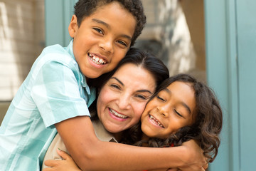 Happy Hispnaic mother laughing and talking with her children.