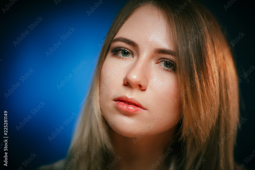 portrait smiling girl on blue background in studio